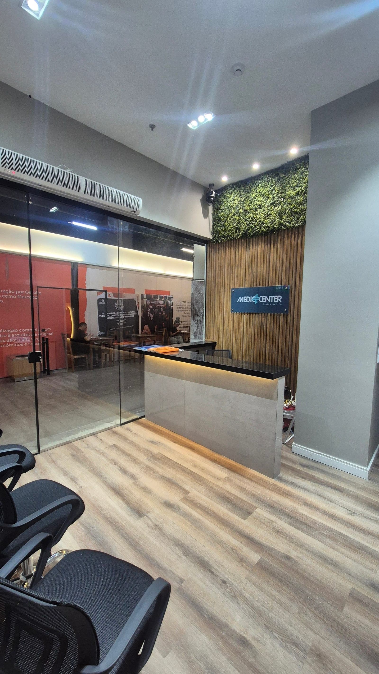 Recepção da Mediccenter, com parede de vidro voltada para o salão do Mercado Municipal de Niterói